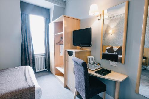 a room with a bed and a desk with a computer at The Station Hotel in Aberdeen