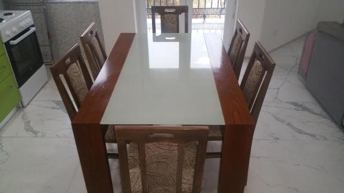 a dining room table with six chairs and a white table at XXL APARTMENTS CiTY CENTAR 1 in Bitola