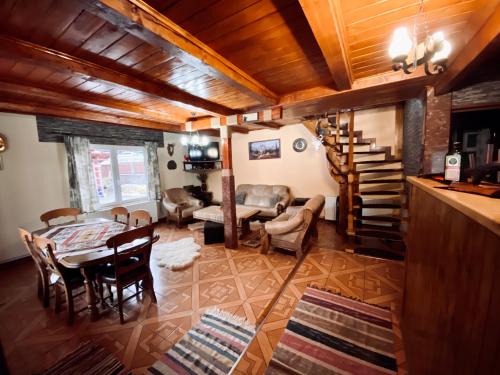 ein Wohnzimmer mit einem Tisch, Stühlen und einem Sofa in der Unterkunft Cabana Scruba in Topliţa