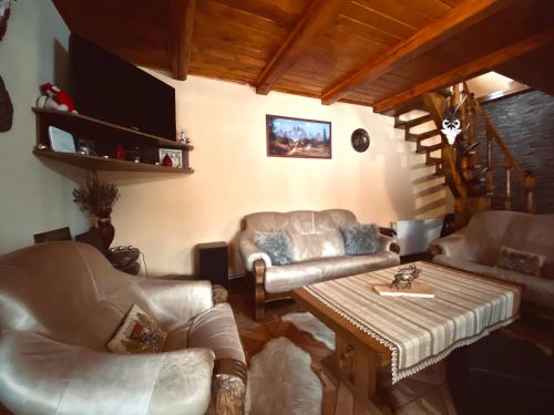 ein Wohnzimmer mit einem Sofa und einem Tisch in der Unterkunft Cabana Scruba in Topliţa