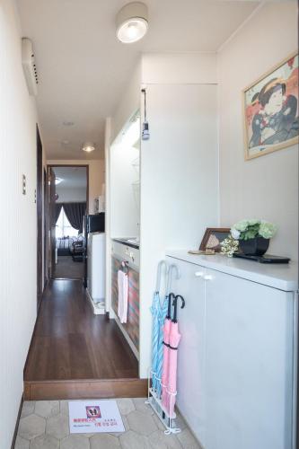 a kitchen with a refrigerator and a hallway at Cozyhouse 211 free wifi a rented electric bicycle in Kyoto