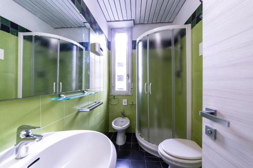 een badkamer met een wastafel, een douche en een toilet bij Park Hotel in Rimini