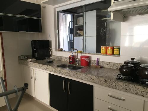 a kitchen with a sink and a counter top at APARTAMENTO ACONCHEGANTE in Uberlândia