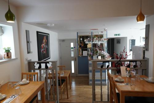オックスフォードにあるオックスフォード ゲスト ハウスの木製のテーブルと椅子のあるレストラン、バー