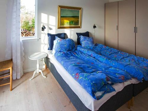 a large bed with a blue comforter in a bedroom at Holiday home Rude II in Rude