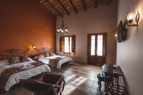 a bedroom with two beds and a desk and a tv at Nono Luigi in Oncativo