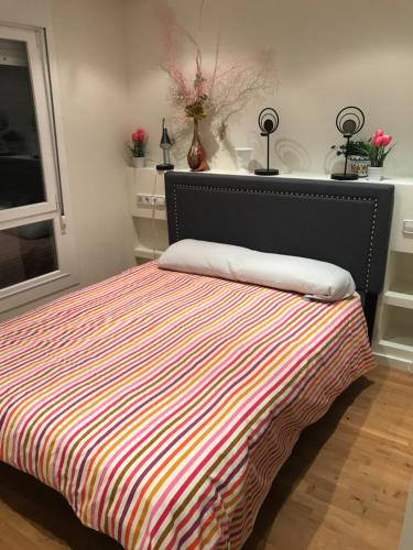 a bedroom with a bed with a striped blanket at Casa Duquesa in Logroño