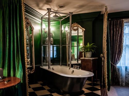 uma casa de banho com uma banheira e uma parede verde em The Rookery em Londres