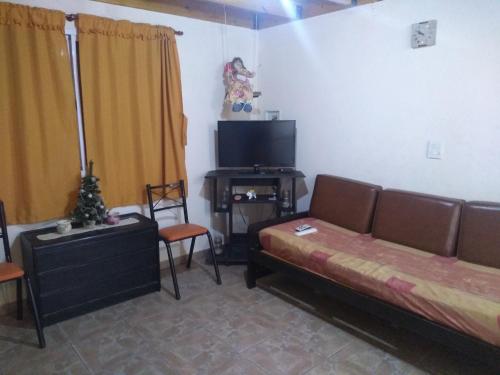 a living room with a couch and a flat screen tv at Cabañas Dulce Atardecer in Villa Carlos Paz