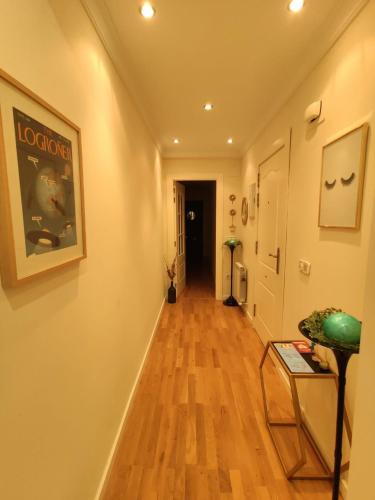 a hallway with a wooden floor and a painting on the wall at Casa Duquesa in Logroño