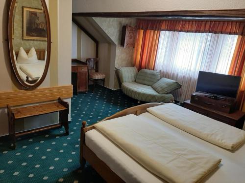 a hotel room with a bed and a mirror at Pension Antik in Bad Lobenstein