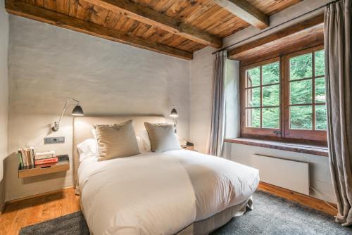 a bedroom with a white bed and a window at Casa Es Pletieus by Totiaran in Arties