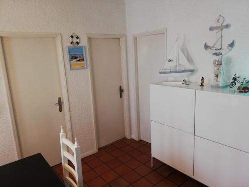 a kitchen with a white cabinet with a boat on it at Casa de Praia in Vila do Conde