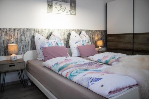 a bed with pillows and a blanket on it at Bergkristall direkt am Bikepark und Skigebiet, 2 Schlafzimmer, Terrasse, abschließbarer Keller in Winterberg