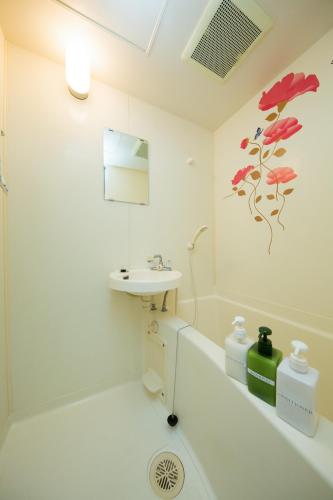 a white bathroom with a sink and a toilet at Cozy house 202, free wifi a rented electric bicycle in Kyoto