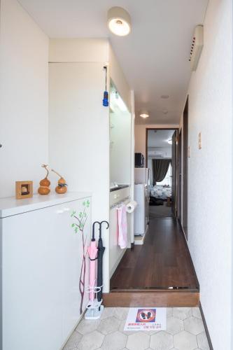 a hallway leading to a kitchen with a refrigerator at Cozy house 202, free wifi a rented electric bicycle in Kyoto