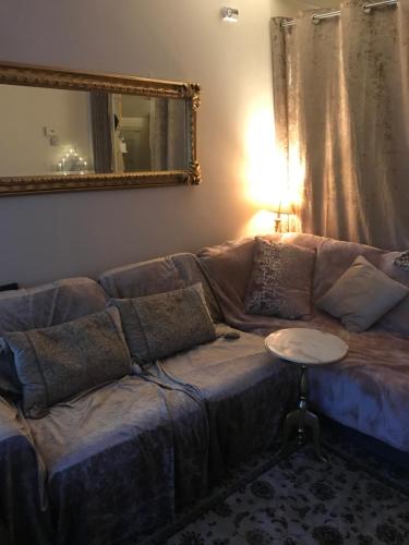 um sofá numa sala de estar com um espelho e uma mesa em Laundry Cottage Apartments em Southampton