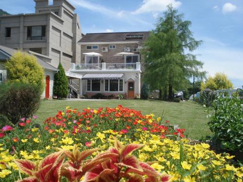 a house with a garden of flowers in front of it at 干城小鎮民宿-包棟-寵物友善 in Jian