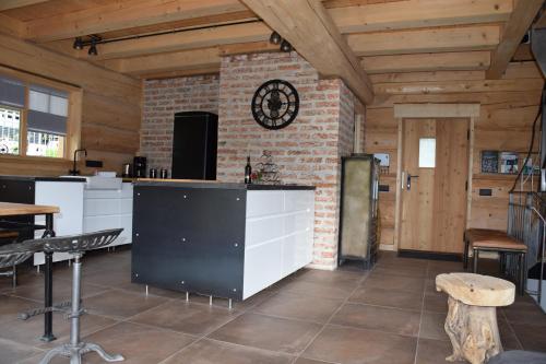 a kitchen with a brick wall and a clock on the wall at Ferienhaus Chalet-Ettal in Ettal