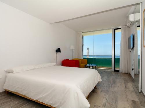 sypialnia z białym łóżkiem i dużym oknem w obiekcie Luxe Penthouse Casa Atlantica Morro Jable Sea Views By PVL w mieście Morro del Jable