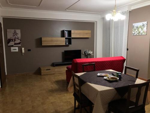 a living room with a table and a red couch at B&B Altamarea in Falerna