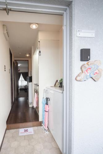 a hallway leading to a kitchen with a refrigerator at Cozy house 411 free wifi a rented electric bicycle in Kyoto