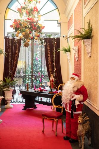a man dressed as santa claus standing in a room with a dog at Raciti Palace in Acireale