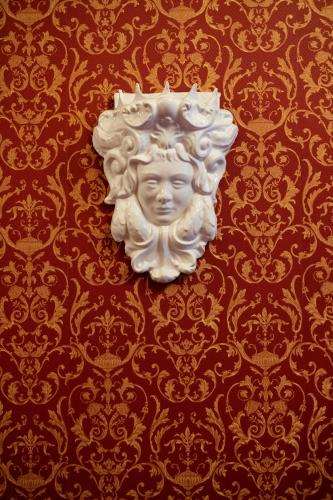 a statue of a head on a red wall at Raciti Palace in Acireale
