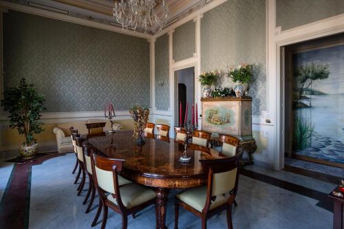a dining room with a wooden table and chairs at Raciti Palace in Acireale