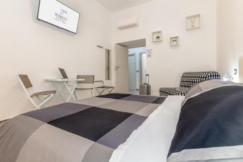 a bedroom with a bed and a table and chairs at Scirocco Rooms in Civitavecchia