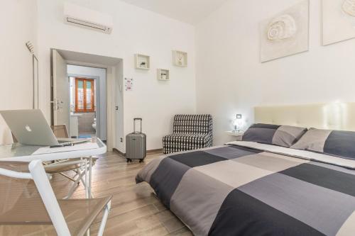 een slaapkamer met een bed en een bureau met een laptop bij Scirocco Rooms in Civitavecchia