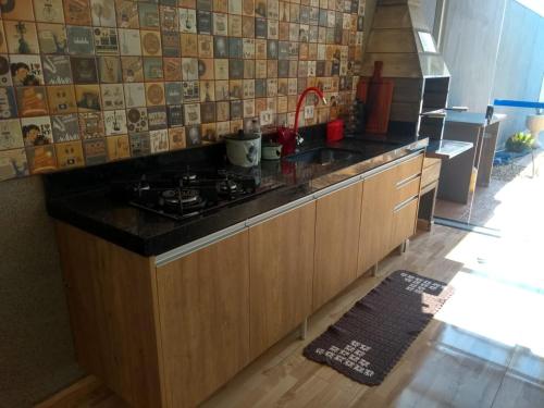 a kitchen with a stove and a counter top at Casa Família Porto in Olímpia