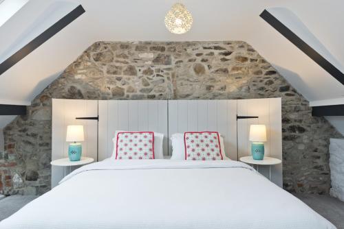 A bed or beds in a room at Connells House Thatched Cottage