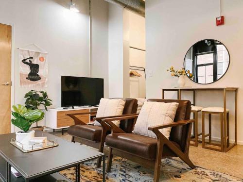 a living room with two chairs and a television at Cozy Downtown Loft in Knoxville