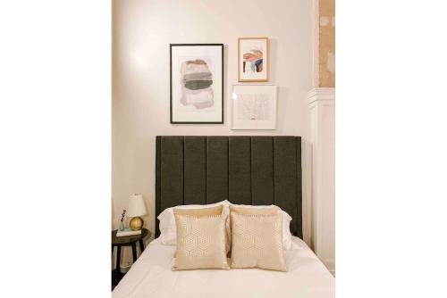 a bedroom with a bed with a black headboard and two pillows at Cozy Downtown Loft in Knoxville