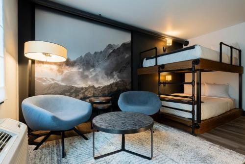 a bedroom with a bunk bed and two chairs and a table at Gravity Haus in Breckenridge