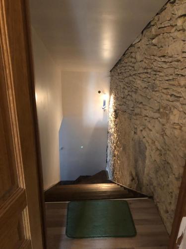 a stairway with a stone wall and a green mat at Gite Augirons in Saint-Ciers-sur-Gironde