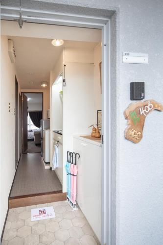 a hallway leading to a kitchen with a refrigerator at Cozy house K46, free wifi a rented electric bicycle in Kyoto