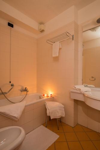 a bathroom with a bath tub and a sink at Hotel Tourist in Valtournenche