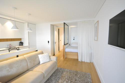 uma sala de estar branca com um sofá e uma cozinha em Center Bay Luxueux appartement avec vue mer 6 eme etage em Juan-les-Pins