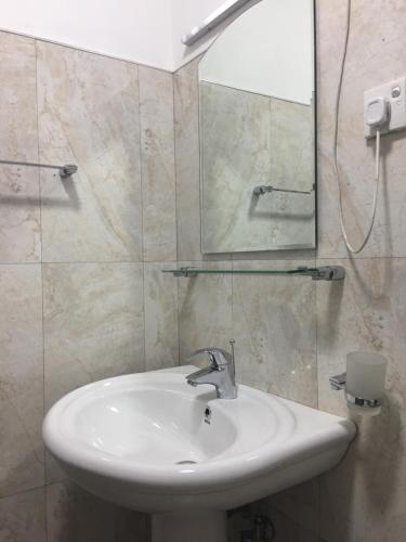 a bathroom with a sink and a mirror at The Fern Inn in Nuwara Eliya