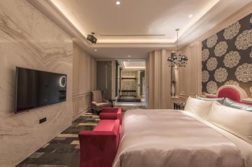 a hotel room with a bed and a flat screen tv at Green Palm Motel in Yuanlin