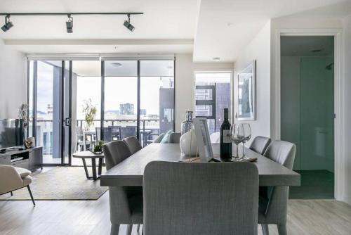 a dining room with a table with a bottle of wine at Arena Convenient 2 Bedroom in Brisbane