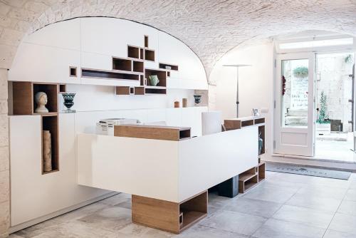 a white kitchen with a counter and shelves at Petrantiche - Albergo Diffuso in Putignano