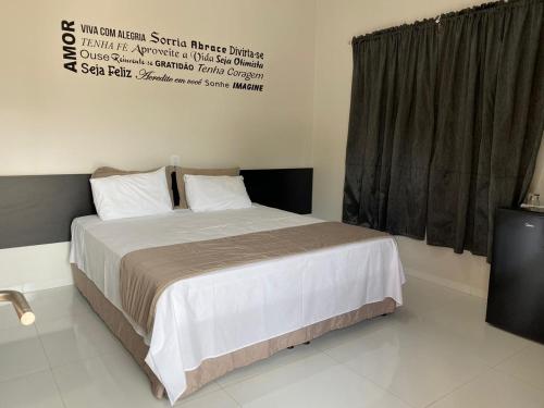 a bedroom with a bed and a sign on the wall at Rossi Hotel in Comodoro