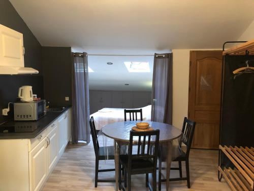 a kitchen and dining room with a table and a bed at Gite Augirons in Saint-Ciers-sur-Gironde