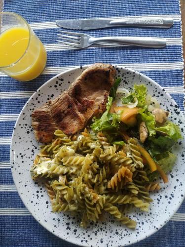 a plate of food with meat and pasta on a table at Green Hostal Popayan in Popayan