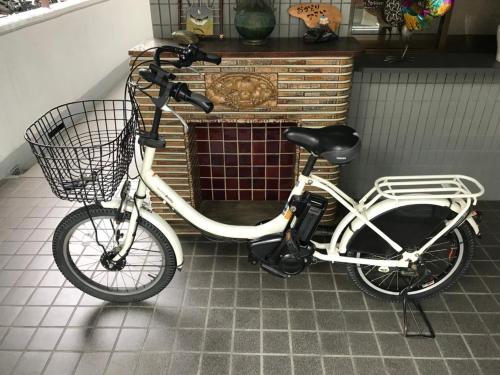a bike with a basket parked in front of a fireplace at Cozy house K46, free wifi a rented electric bicycle in Kyoto