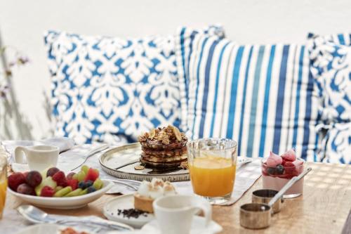 een tafel met pannenkoeken en fruit bij VOTSALO - Semi Based Studio with Indoor Garden - Part Of White Dunes Luxury Boutique Hotel in Naousa