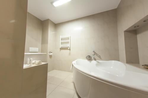 a white bathroom with a tub and a sink at Hotel Tychy Prime in Tychy
